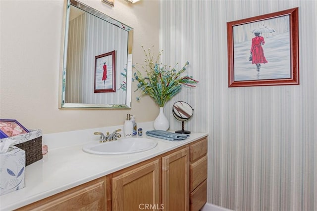 bathroom featuring vanity and wallpapered walls