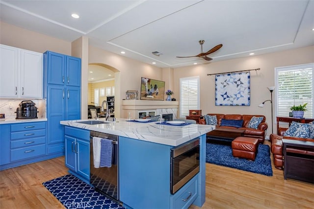 kitchen featuring open floor plan, blue cabinets, a sink, and stainless steel appliances