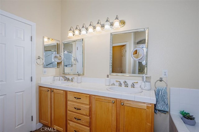 bathroom featuring a sink, double vanity, and tiled tub