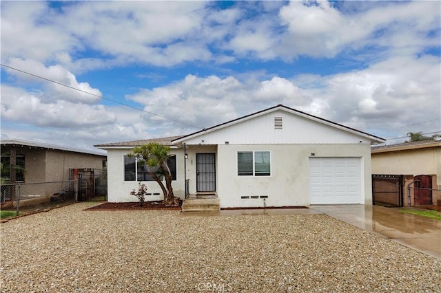 view of front of home with an attached garage, driveway, fence, and stucco siding
