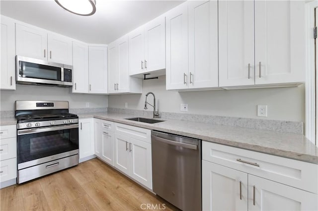 kitchen featuring white cabinetry, stainless steel appliances, and a sink