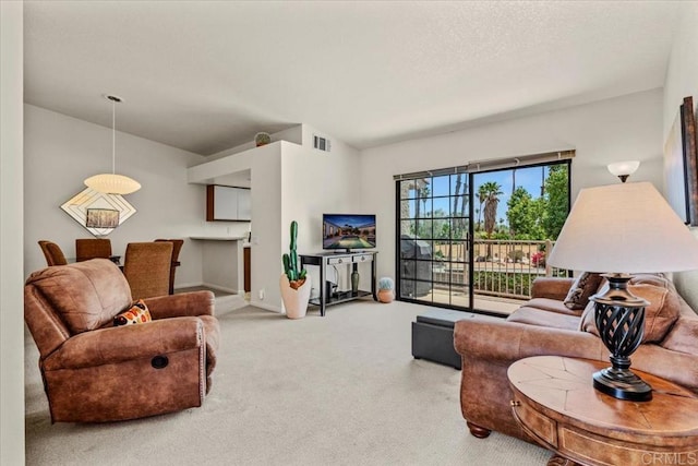 carpeted living area with visible vents and a textured ceiling