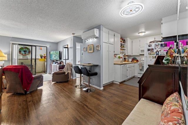 6330 Genesee Ave Unit 119, San Diego, CA 92122 - living room with a wall mounted air conditioner, dark wood-type flooring, and a textured ceiling