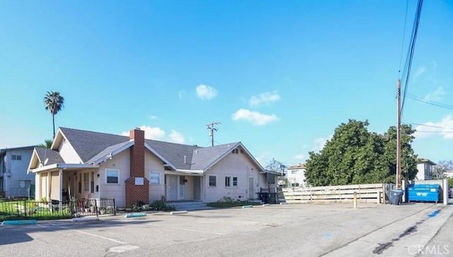 view of front of property featuring a chimney and fence