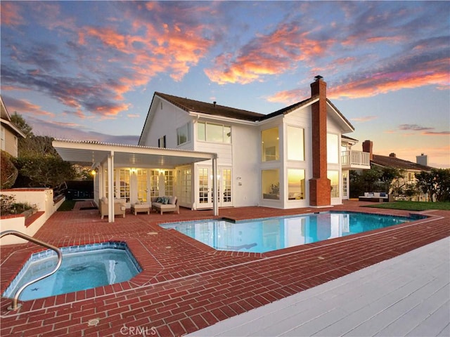 49 Country Ln, Rolling Hills Estates, CA 90274 - back of property at dusk with an outdoor hangout area, french doors, a balcony, an in ground hot tub, and a patio area
