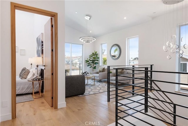 entrance foyer featuring an inviting chandelier, lofted ceiling, light wood-style flooring, and recessed lighting