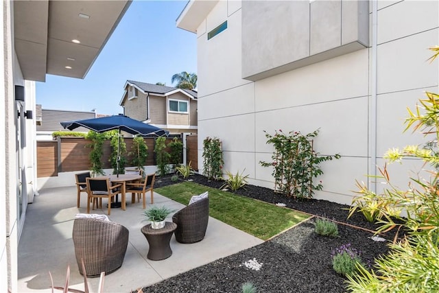 view of patio with outdoor dining area and fence