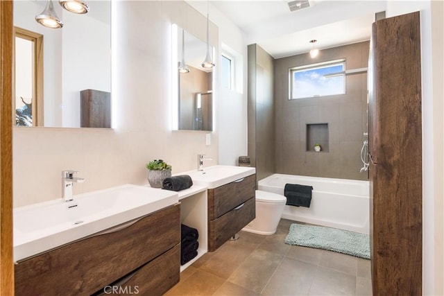 bathroom featuring visible vents, two vanities, a sink, tile patterned floors, and toilet