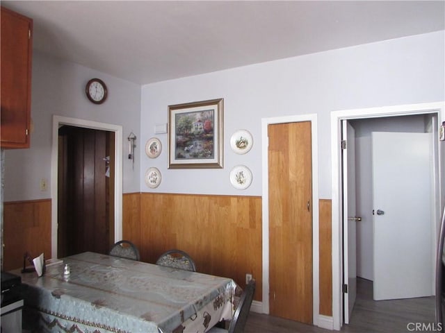2956 W 15th St, Los Angeles, CA 90006 - dining area featuring a wainscoted wall, wooden walls, and wood finished floors