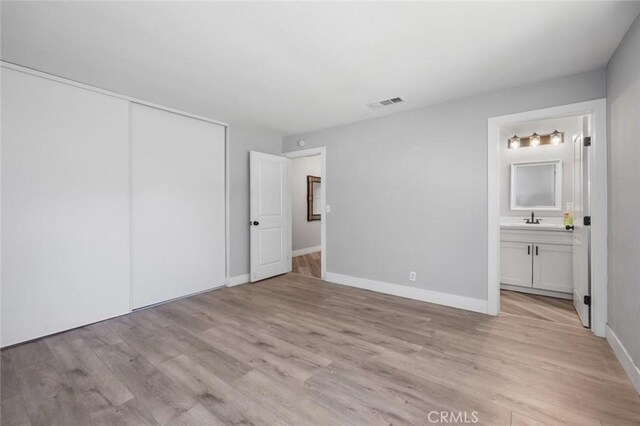 11911 Ivy Ln, Moreno Valley, CA 92557 - unfurnished bedroom with a sink, light wood finished floors, a closet, connected bathroom, and baseboards