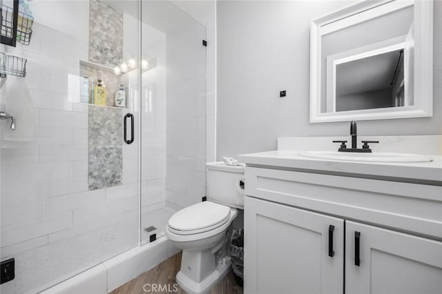 11911 Ivy Ln, Moreno Valley, CA 92557 - bathroom featuring toilet, vanity, a stall shower, and wood finished floors