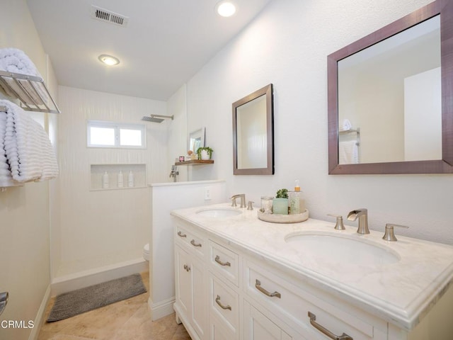full bath with a sink, visible vents, toilet, and walk in shower