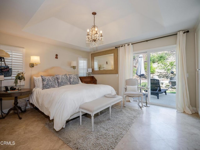 bedroom with a raised ceiling, a notable chandelier, and access to exterior