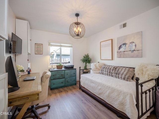 bedroom featuring light wood-style floors, visible vents, and a chandelier