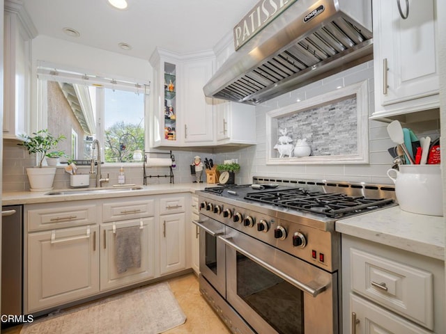 kitchen with a sink, white cabinetry, ventilation hood, range with two ovens, and glass insert cabinets