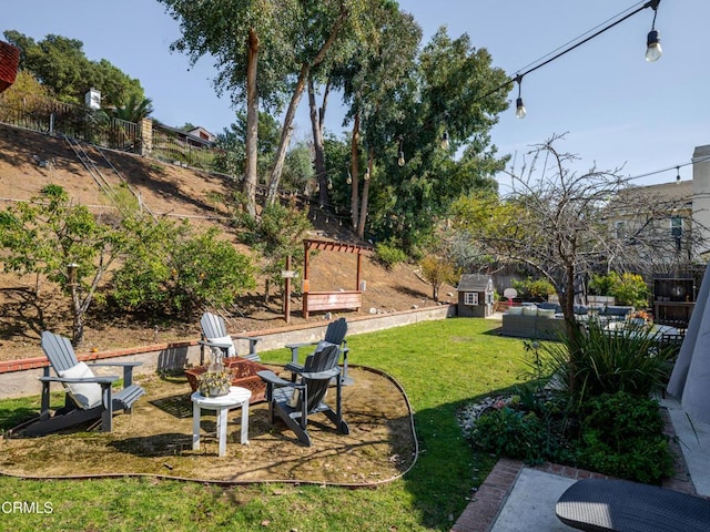 view of yard featuring a patio area, a fire pit, and fence