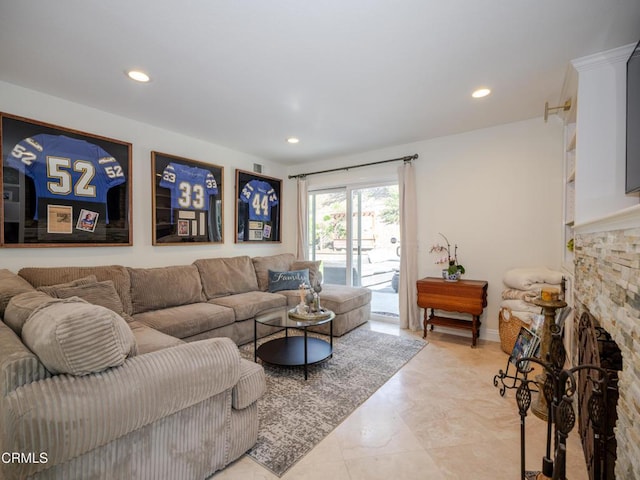 living area with a stone fireplace and recessed lighting