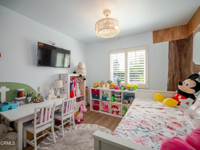 bedroom with an inviting chandelier and wood finished floors