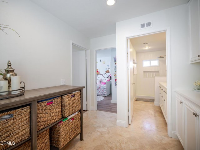 corridor with baseboards and visible vents