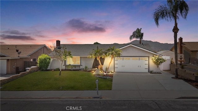 ranch-style home with fence, an attached garage, stucco siding, concrete driveway, and a lawn