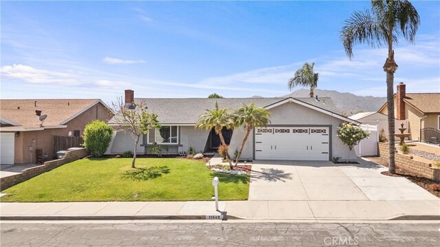 ranch-style home with fence, a front lawn, concrete driveway, an attached garage, and stucco siding