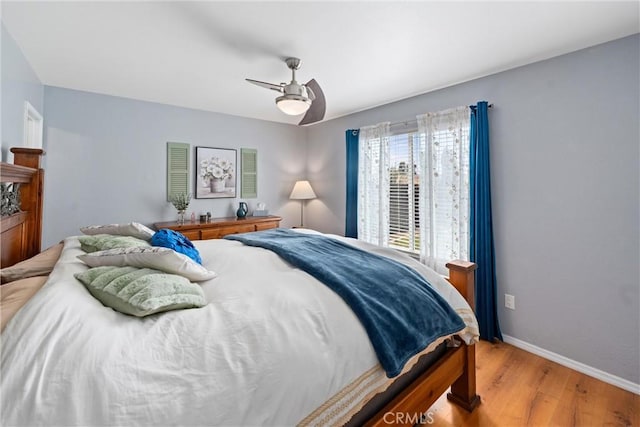 bedroom featuring baseboards, ceiling fan, and light wood-type flooring