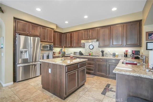 31973 Wildwood Ct, Temecula, CA 92592 - kitchen featuring stainless steel appliances, a sink, light stone countertops, under cabinet range hood, and light tile patterned floors