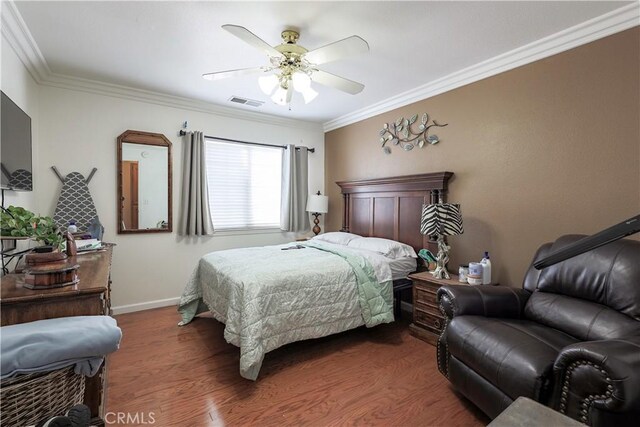 bedroom with wood finished floors, baseboards, visible vents, ceiling fan, and ornamental molding