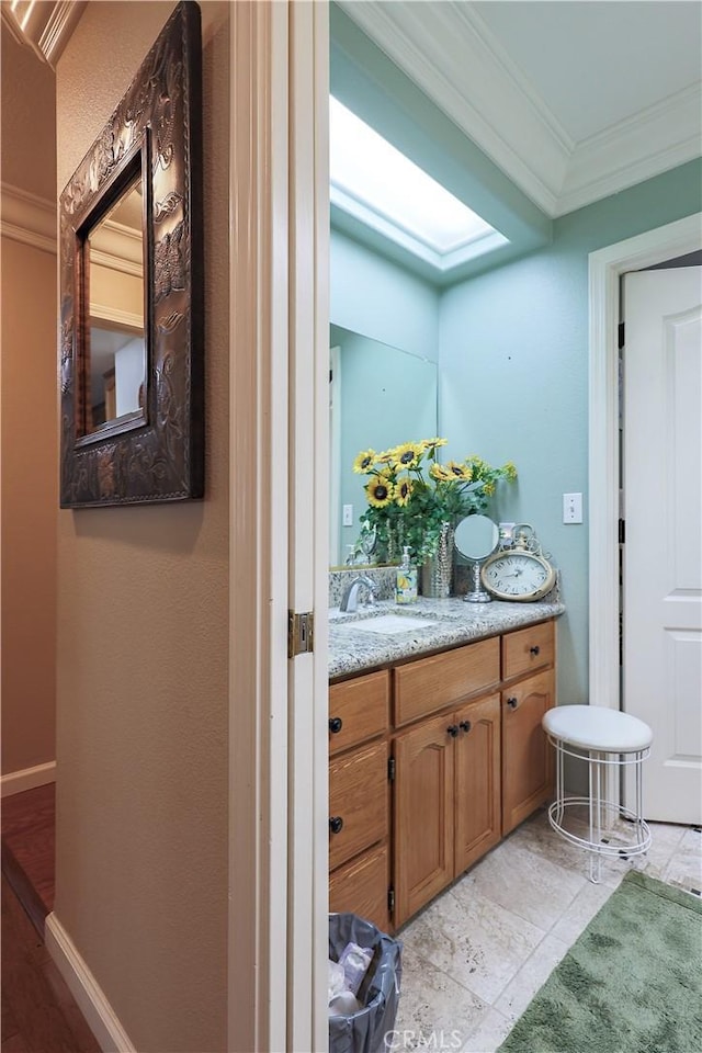 bathroom featuring vanity, baseboards, and ornamental molding