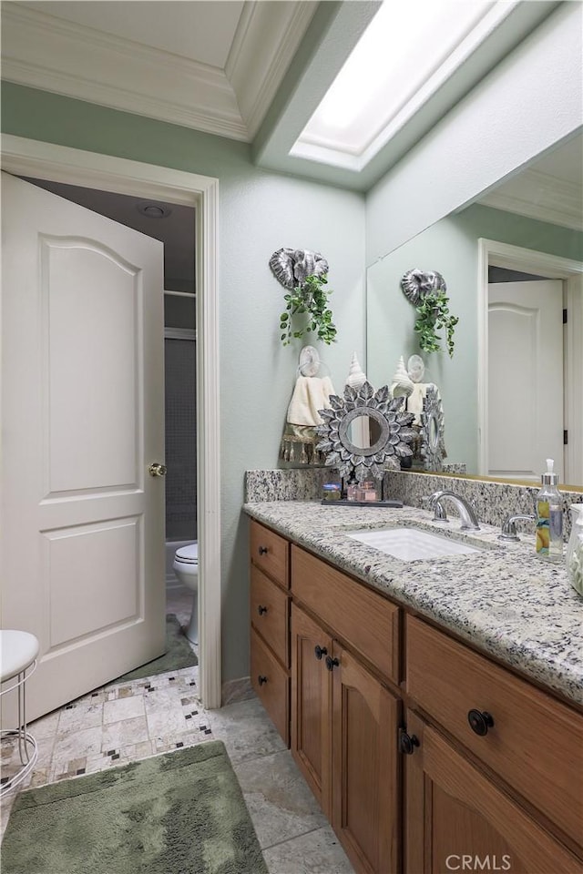 bathroom featuring toilet, vanity, and crown molding