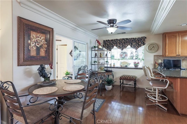 dining room with visible vents, wood-type flooring, ceiling fan, and crown molding