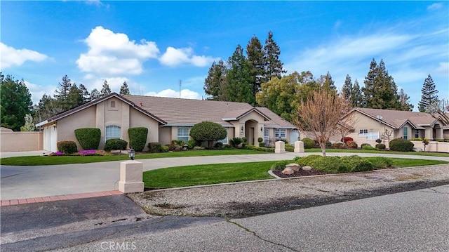 single story home with stucco siding, curved driveway, a front yard, and a tiled roof