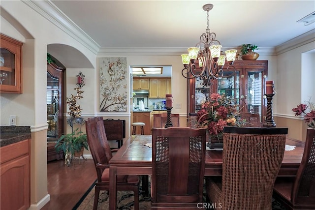 dining space with a chandelier, wood finished floors, and ornamental molding