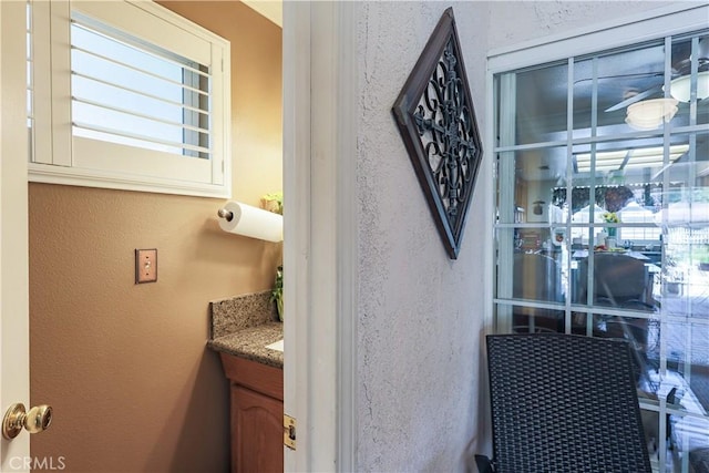 interior space with plenty of natural light, vanity, and a textured wall