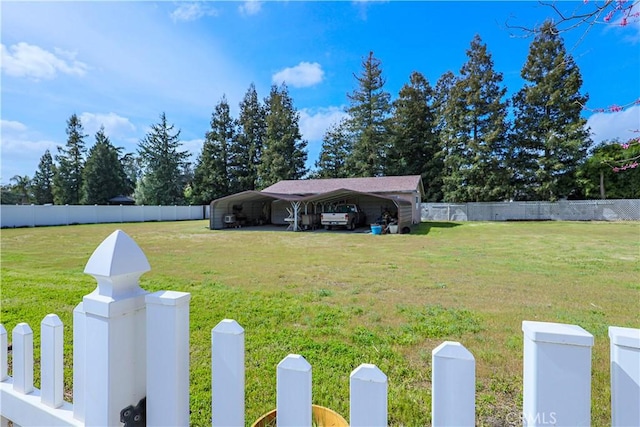 view of yard with a detached carport and fence