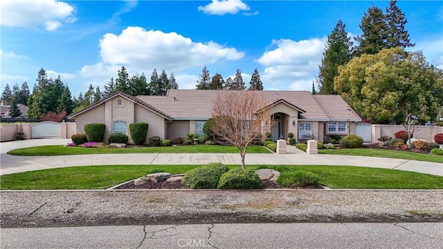 ranch-style house with stucco siding, a front lawn, and a gate