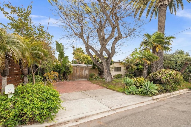 exterior space featuring concrete driveway, stucco siding, and fence