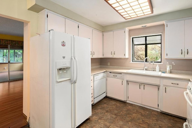 kitchen featuring a sink, white appliances, light countertops, and white cabinets