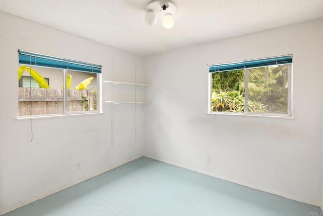 spare room featuring finished concrete flooring and a textured ceiling