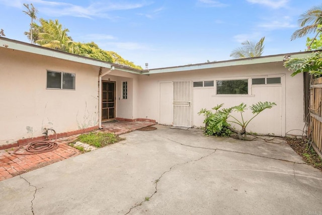 property entrance featuring a patio area and stucco siding