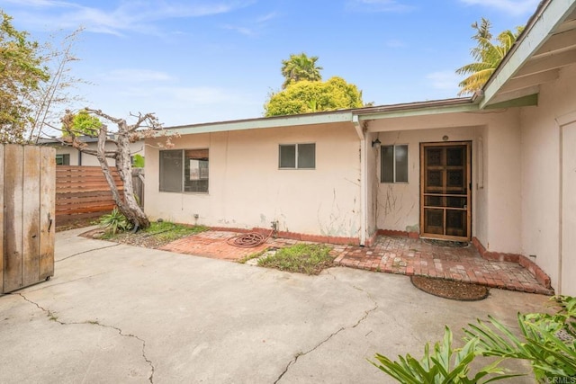 back of property with a patio area, stucco siding, and fence