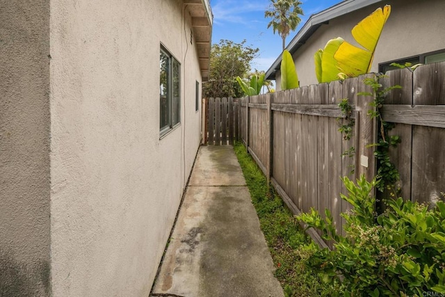 view of side of property featuring stucco siding and fence