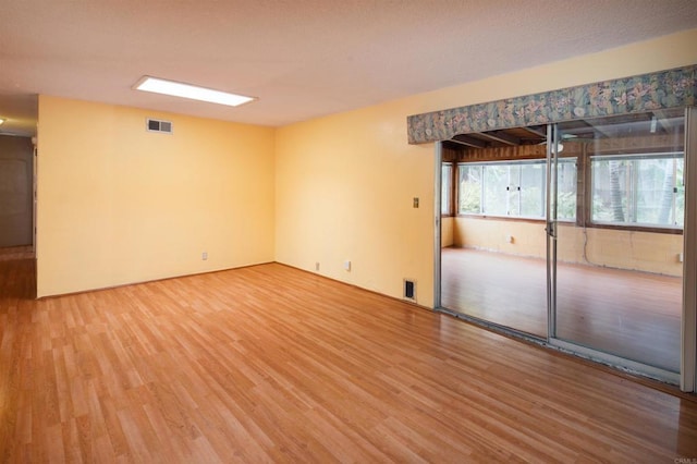 empty room featuring visible vents and light wood-style flooring