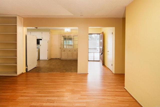 hall featuring a textured ceiling and light wood-style flooring