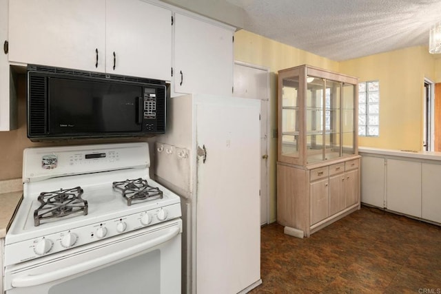 kitchen featuring white cabinets, light countertops, a textured ceiling, and white gas stove
