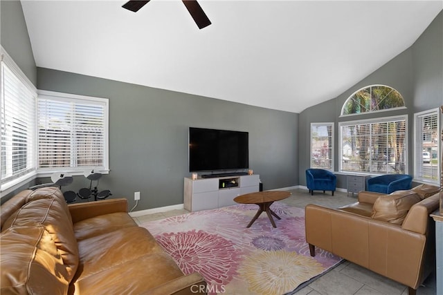 living area featuring a ceiling fan, baseboards, plenty of natural light, and high vaulted ceiling