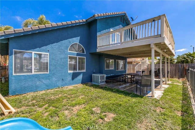 rear view of house with a lawn, a patio, a fenced backyard, and stucco siding