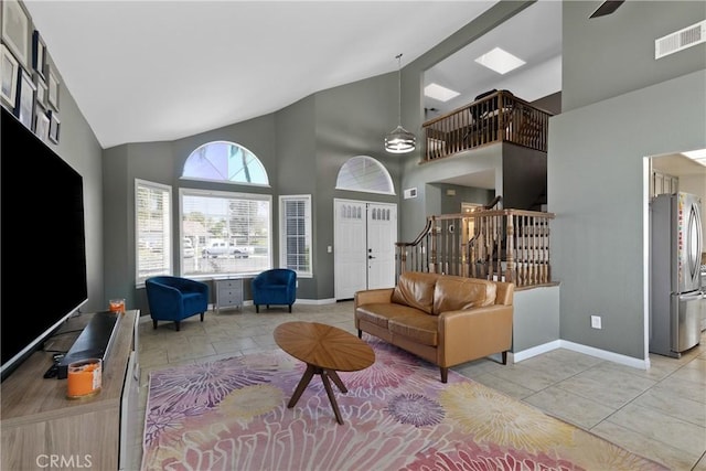living room featuring light tile patterned flooring, high vaulted ceiling, baseboards, visible vents, and stairway