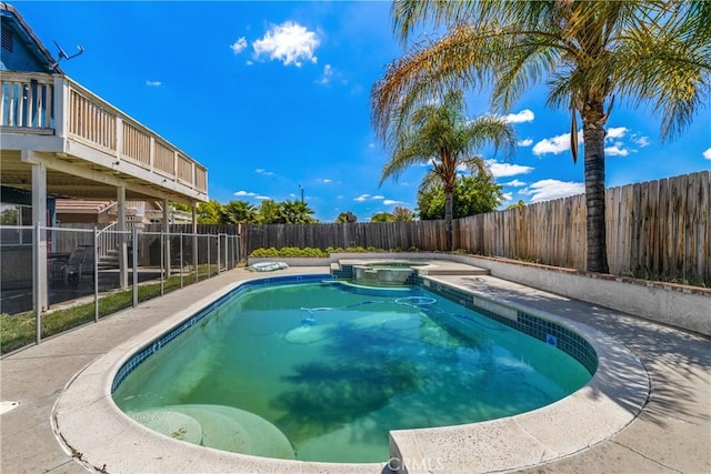 view of pool with a fenced backyard and a pool with connected hot tub