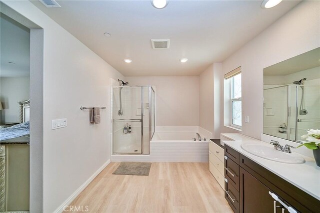 full bath featuring vanity, wood finished floors, visible vents, a shower stall, and a garden tub